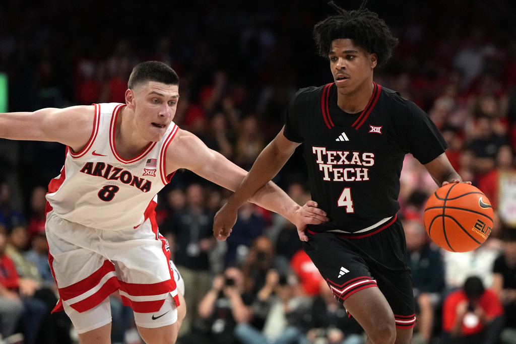 Texas Tech guard Christian Anderson (4) drives past Arizona forward Ivan Kharchenkov during the first half of an NCAA college basketball game, Saturday, Feb. 14, 2026, in Tucson, Ariz. (AP Photo/Rick Scuteri)