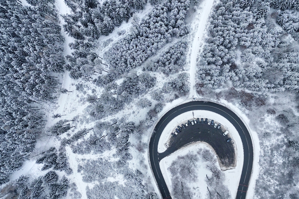 Cars drive around a curve in a snow covered forest of the Taunus region near Frankfurt, Germany, Tuesday, Jan. 6, 2026. (AP Photo/Michael Probst)