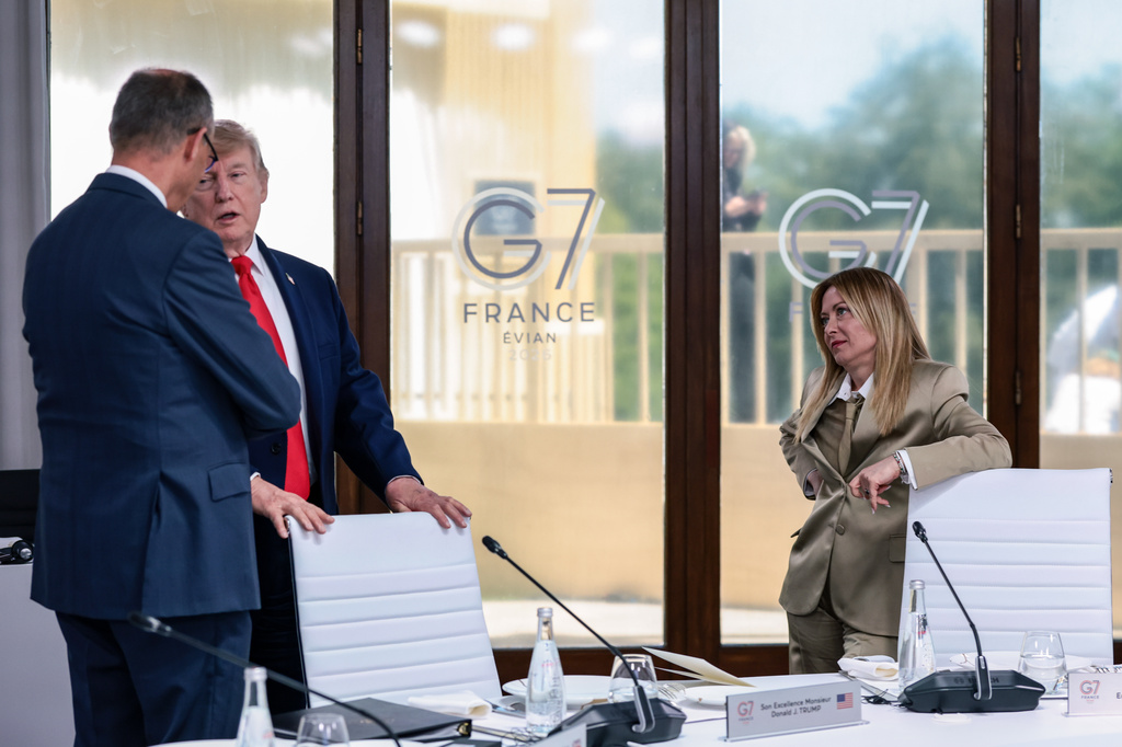 U.S. President Donald Trump, center, speaks with German Chancellor Friedrich Merz, left, and Italian Prime Minister Giorgia Meloni, right, at a working lunch with leaders of G7 and the Middle East, in Evian-les-Bains, France, Tuesday, June 16, 2026. (Evelyn Hockstein/Pool Photo via AP)