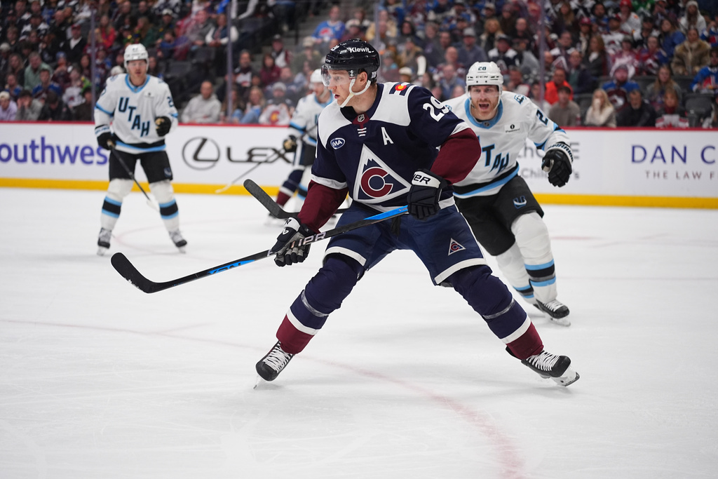 FILE - Colorado Avalanche center Nathan MacKinnon (29) and Utah Mammoth defenseman Nate Schmidt (88) in the third period of an NHL hockey game Tuesday, Dec. 23, 2025, in Denver. (AP Photo/David Zalubowski, File)