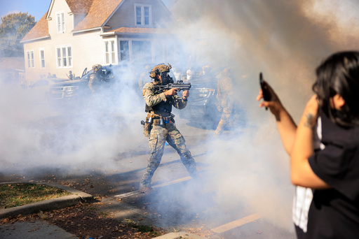 A U.S. Customs and Border Protection agent points a non-lethal weapon at protesters in East Side, Chicago, Tuesday, Oct. 14, 2025. (Anthony Vazquez/Chicago Sun-Times via AP) A U.S. Customs and Border Protection agent points a non-lethal weapon at protesters in East Side, Chicago, Tuesday, Oct. 14, 2025. (Anthony Vazquez/Chicago Sun-Times via AP)