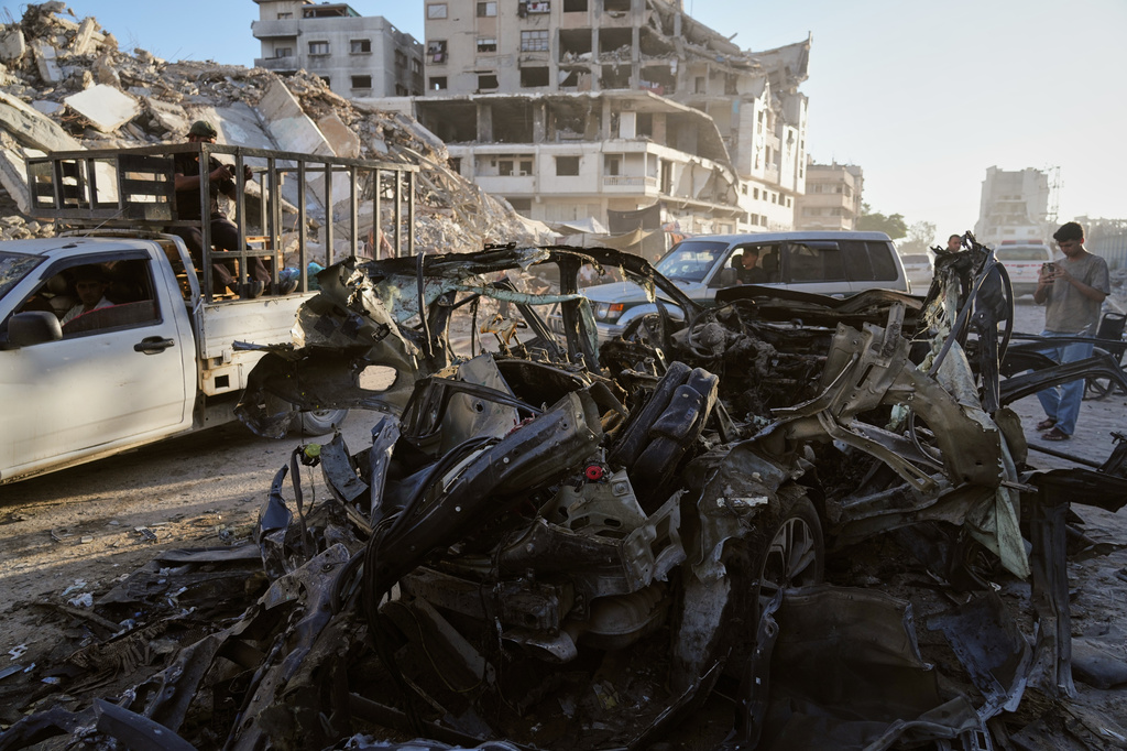 Palestinians inspect the wreckage of a car after it was hit by an Israeli strike in Gaza City, Sunday, Sept. 27, 2026. (AP Photo/Jehad Alshrafi)