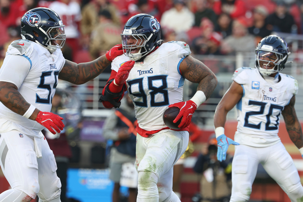 Tennessee Titans defensive tackle Jeffery Simmons (98) celebrates his touchdown with offensive tackle JC Latham, left, and running back Tony Pollard (20) during the second half of an NFL football game against the San Francisco 49ers, Sunday, Dec. 14, 2025, in Santa Clara, Calif. (AP Photo/Jed Jacobsohn)