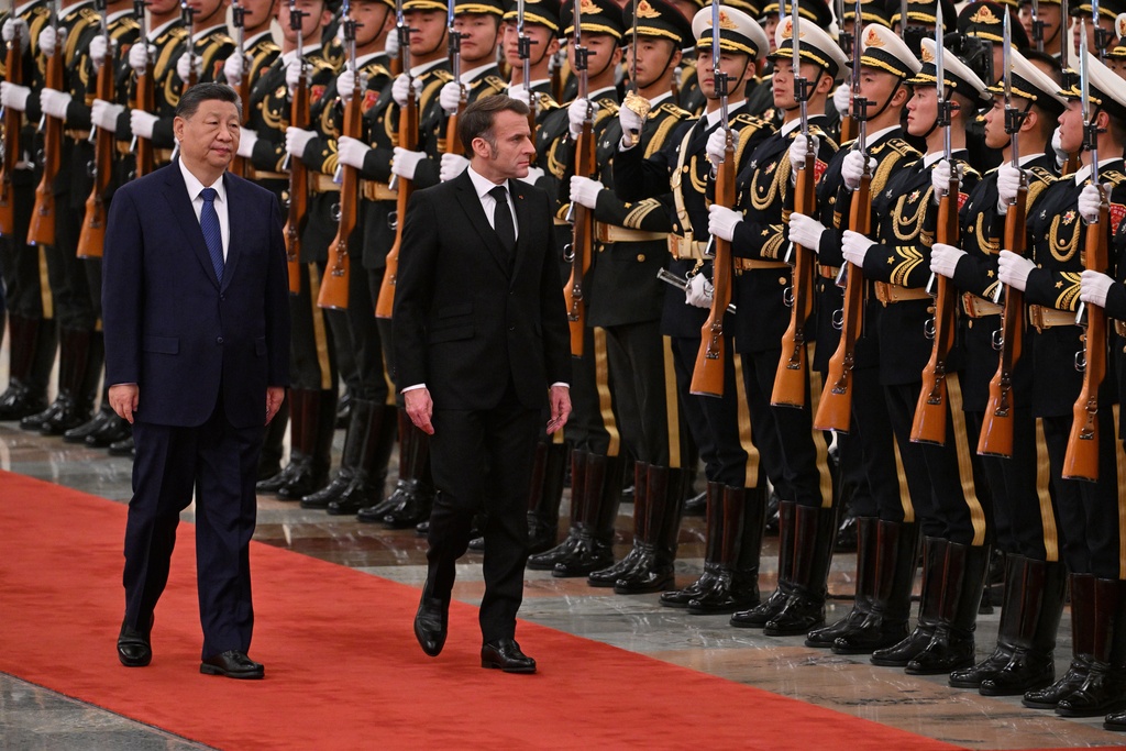 France's President Emmanuel Macron, right, and China's President Xi Jinping, left, review honour guards during a state visit at the Great Hall of the People in Beijing Thursday, Dec. 4, 2025. (Adek Berry/Pool Photo via AP)