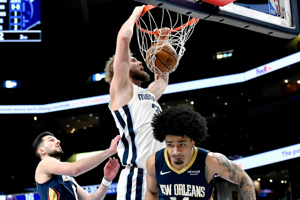 Memphis Grizzlies center Jock Landale (31) dunks over New Orleans Pelicans forward Karlo Matkovic, left, and guard Micah Peavy, right, in the first half of an NBA basketball game Friday, Jan. 23, 2026, in Memphis, Tenn. (AP Photo/Brandon Dill)