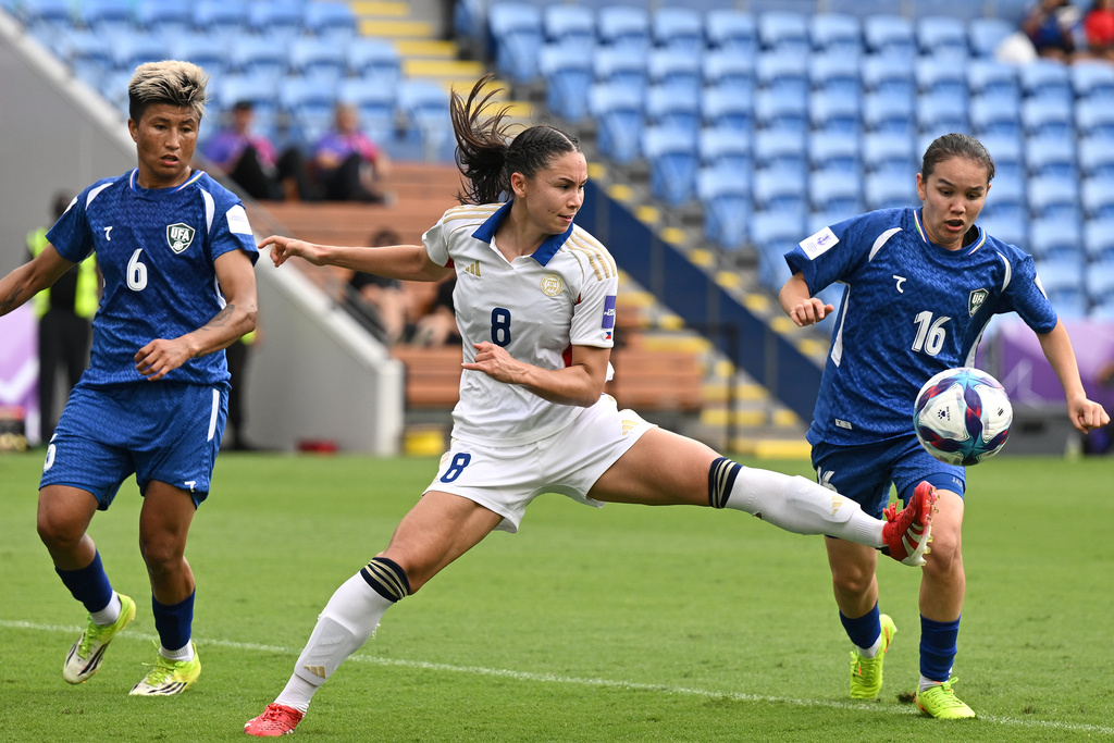 Sara Eggesvik of Philippines battles for the ball with Uzbekistan's Zarina Mamatkarimova, right, during the Women's Asian Cup qualifying match for the World Cup, at Gold Coast Stadium In Robina, Australia, Thursday, March 19, 2026. (Dave Hunt/AAP Image via AP)