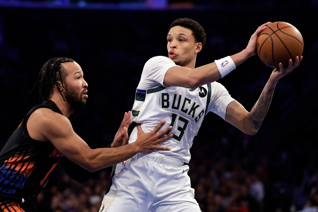 Milwaukee Bucks guard Ryan Rollins (13) looks to pass around New York Knicks guard Jalen Brunson during the first half of an NBA basketball game, Friday, Nov. 28, 2025, in New York. (AP Photo/Adam Hunger)