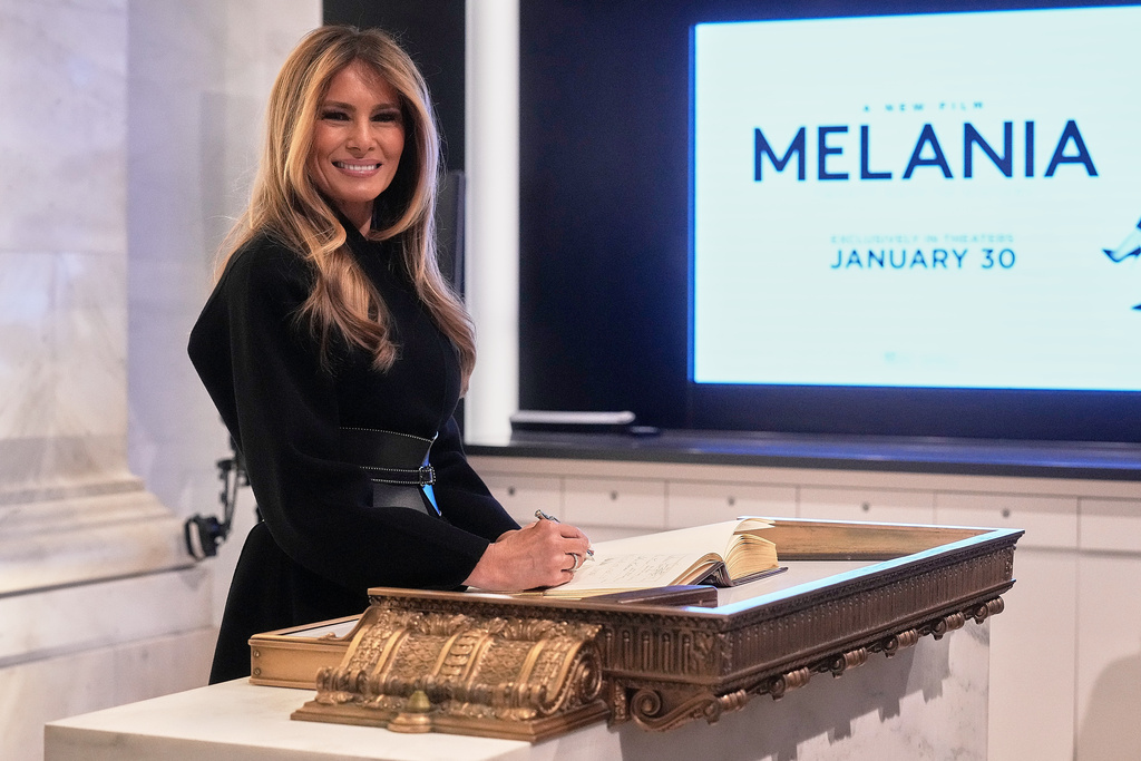 First lady Melania Trump signs the book on the floor of the New York Stock Exchange before ringing the opening bell, Wednesday, Jan. 28, 2026. (AP Photo/Richard Drew)