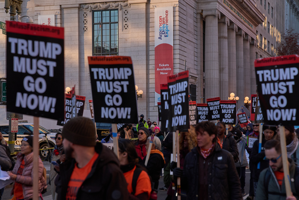 Protesters march past the Milken Center for Advancing the American Dream, during a "Trump Must Go Now!" rally by the White House, Monday, Nov. 17, 2025, in Washington. (AP Photo/Jacquelyn Martin)