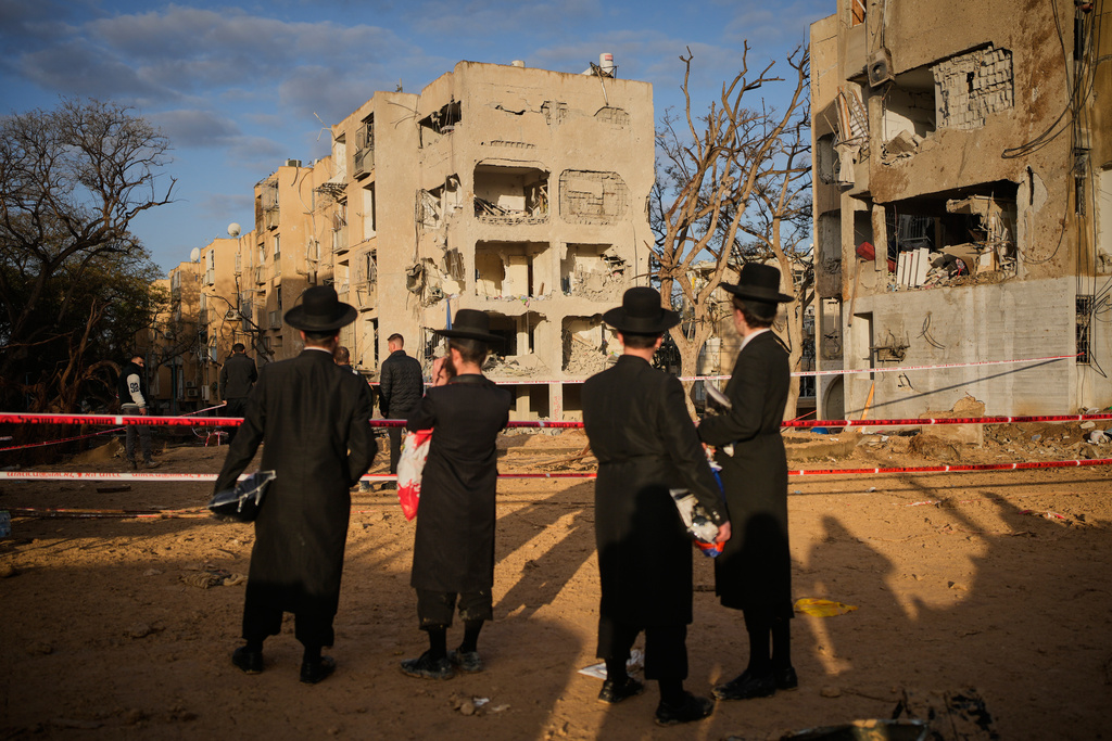 People look at residential buildings heavily damaged by an Iranian missile strike in Arad, southern Israel, Sunday, March 22, 2026. (AP Photo/Ohad Zwigenberg)