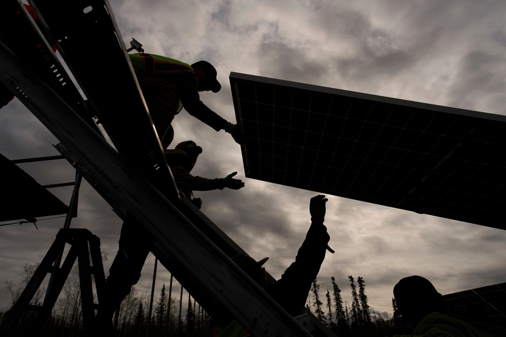 FILE - Workers install panels at a solar project May 21, 2025, in Galena, Alaska. (AP Photo/John Locher, File)
