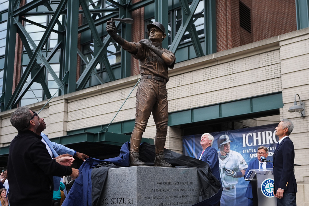 Former Seattle Mariners Edgar Martinez, left, and Ken Griffey Jr., second from left, look on with right fielder Ichiro Suzuki, right, at the broken bat of Ichiro's statue during its unveiling outside of T-Mobile Park, Friday, April 10, 2026, in Seattle. (AP Photo/Lindsey Wasson)
