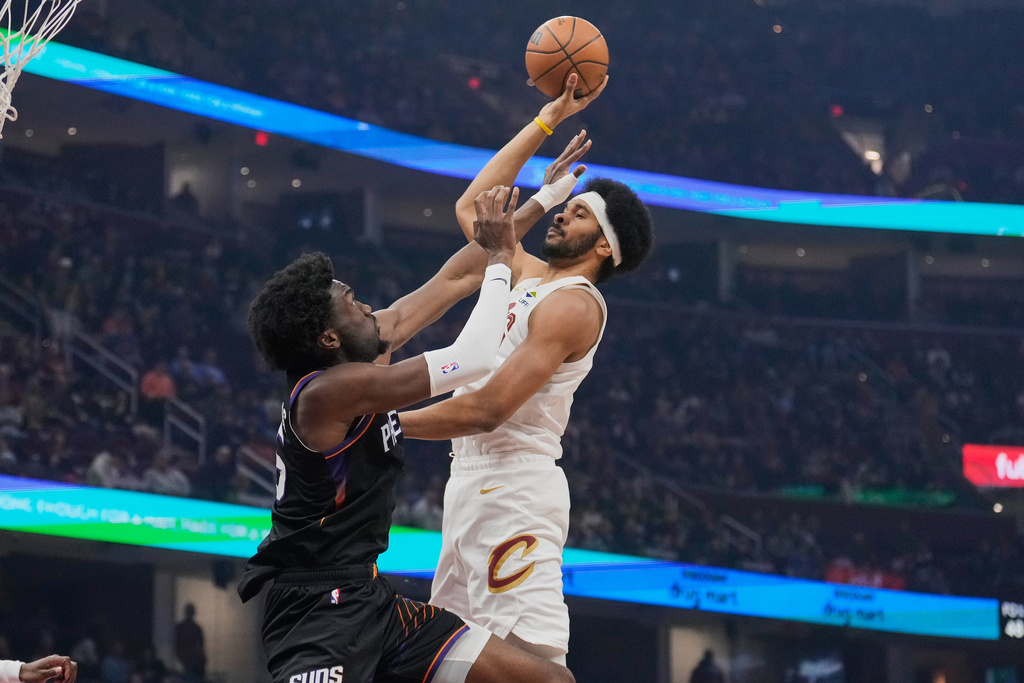 Cleveland Cavaliers center Jarrett Allen, right, shoots as Phoenix Suns center Mark Williams, left, defends in the first half of an NBA basketball game Wednesday, Dec. 31, 2025, in Cleveland. (AP Photo/Sue Ogrocki)