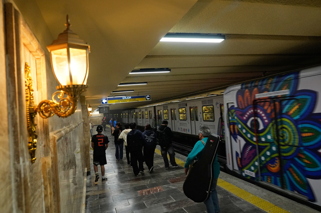 People walk through a subway station that has new lighting, part of preparations for hosting the World Cup soccer tournament in Mexico City, Wednesday, June 10, 2026. (AP Photo/Marco Ugarte)