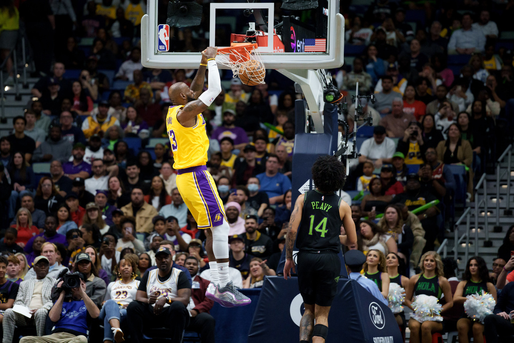 Los Angeles Lakers forward LeBron James (23) dunks next to New Orleans Pelicans guard Micah Peavy (14) during the first half of an NBA basketball game in New Orleans, Tuesday, Jan. 6, 2026. (AP Photo/Matthew Hinton)