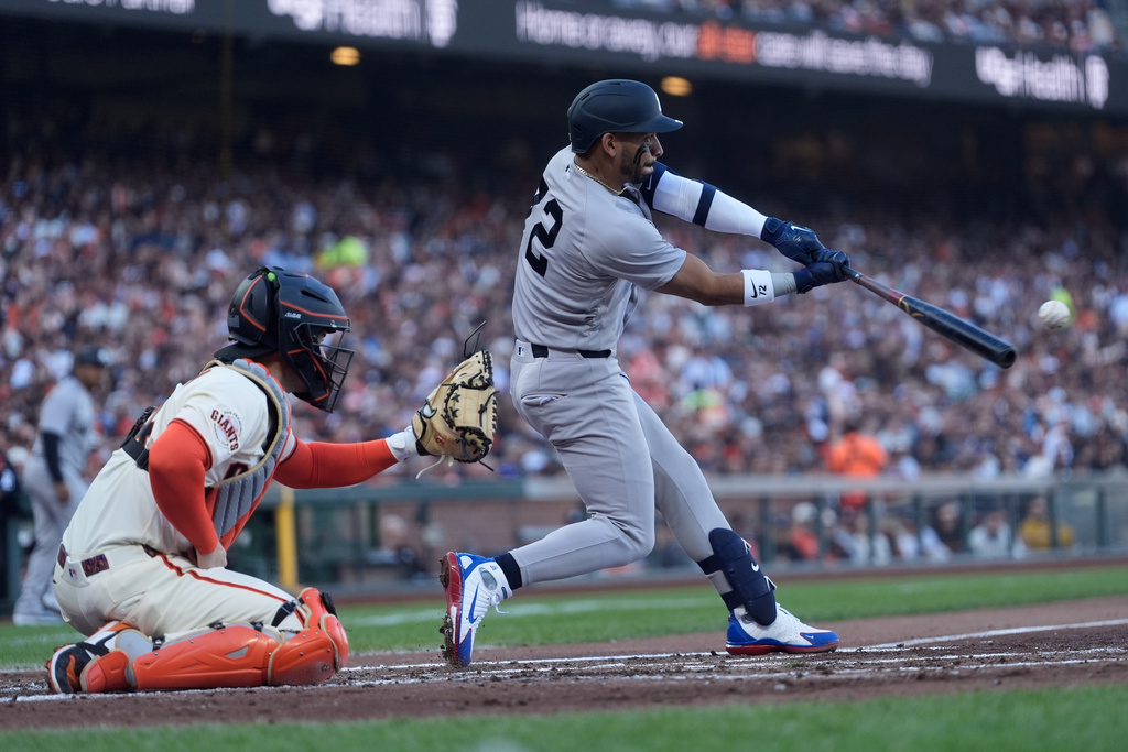 New York Yankees' José Caballero, right, hits an RBI double in front of San Francisco Giants catcher Patrick Bailey, left, during the second inning of a baseball game in San Francisco, Wednesday, March 25, 2026. (AP Photo/Jeff Chiu)