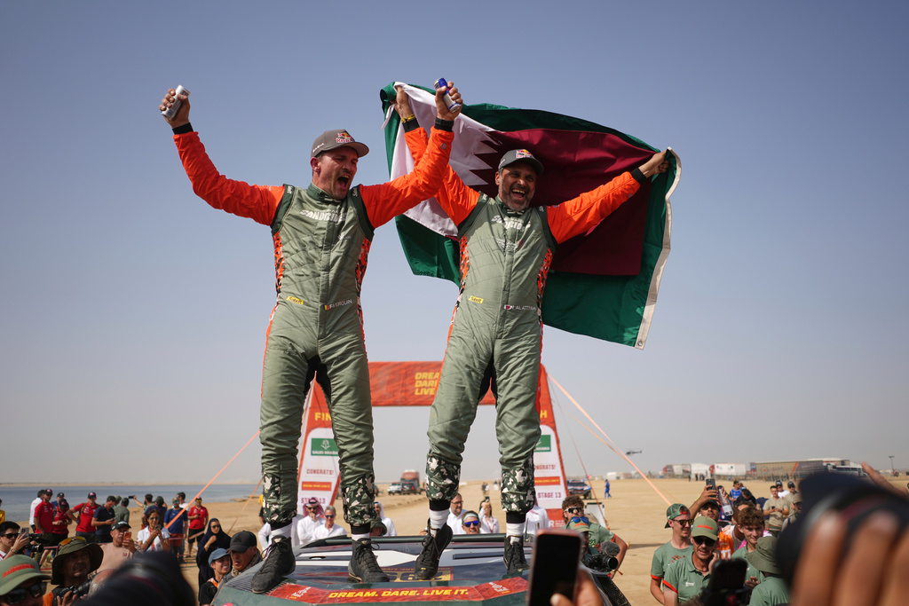 Driver Nasser Al-Attiyah of Qatar, right, and co-driver Fabian Lurquin of Belgium celebrate winning the Dakar Rally after the thirteenth stage with a start and finish in Yanbu, Saudi Arabia, Saturday, Jan.17, 2026. (AP Photo/Thibault Camus)