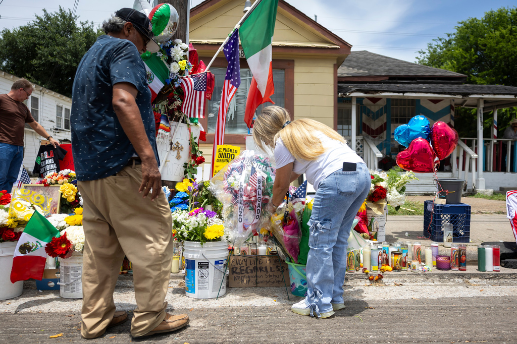 A woman who wished to be identified by her last name Faith places a homemade wreath at the site where Lorenzo Salgado Araujo was shot by an ICE officer in Houston, Friday, July 10, 2026. (AP Photo/Annie Mulligan)