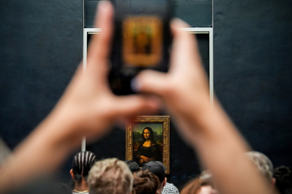 FILE - A person photographs Leonardo da Vinci's painting Mona Lisa at the Louvre museum, Aug. 31, 2025, in Paris. (AP Photo/Julia Demaree Nikhinson, file)