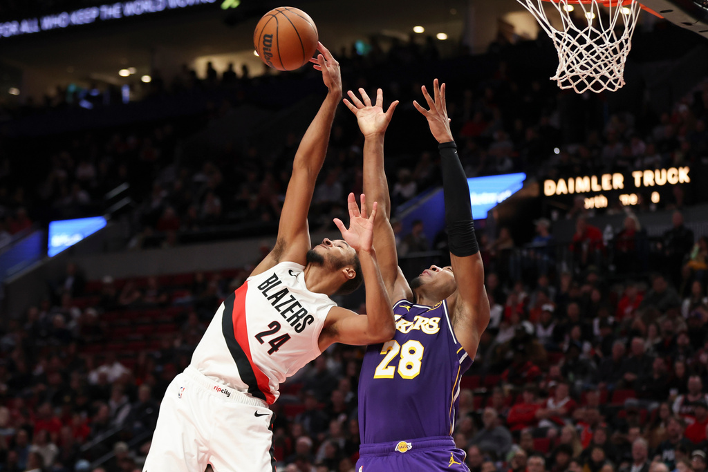 Portland Trail Blazers forward Kris Murray (24) and Los Angeles Lakers forward Rui Hachimura (28) grab for a rebound during the first half of an NBA basketball game Monday, Nov. 3, 2025, in Portland, Ore. (AP Photo/Amanda Loman)