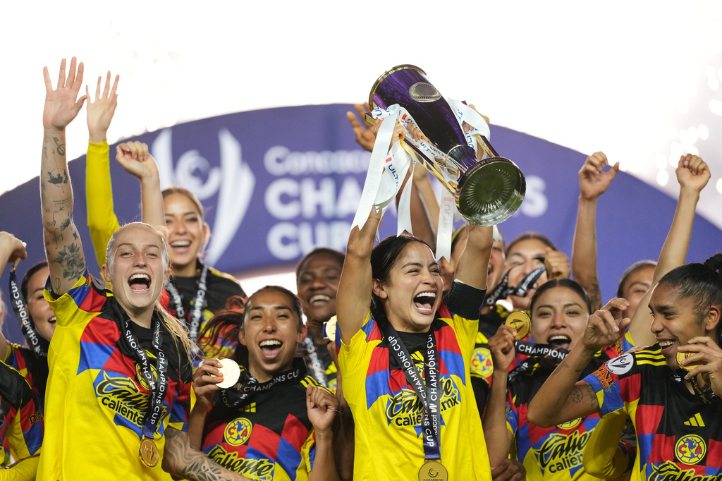 Scarlett Camberos of Mexico's America, center, lifts the trophy after winning the Women's CONCACAF Champions Cup final soccer match against The United States' Washington Spirit in Pachuca, Mexico, Saturday, May 23, 2026.(AP Photo/Fernando Llano)