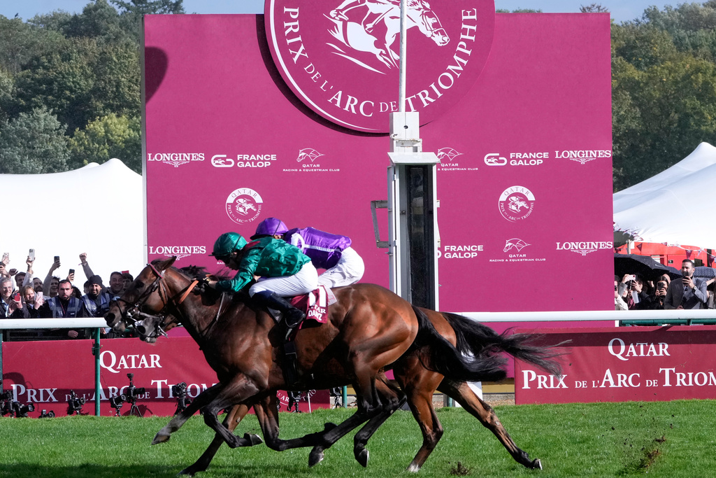Daryz (11) ridden by Mickael Barzalona crosses the finish line to win the Qatar Arc de Triomphe horse race ahead of Minie Hauk ridden by Christophe Soumillon, behind, Sunday, Oct. 5, 2025 in Paris. (AP Photo/Michel Euler)