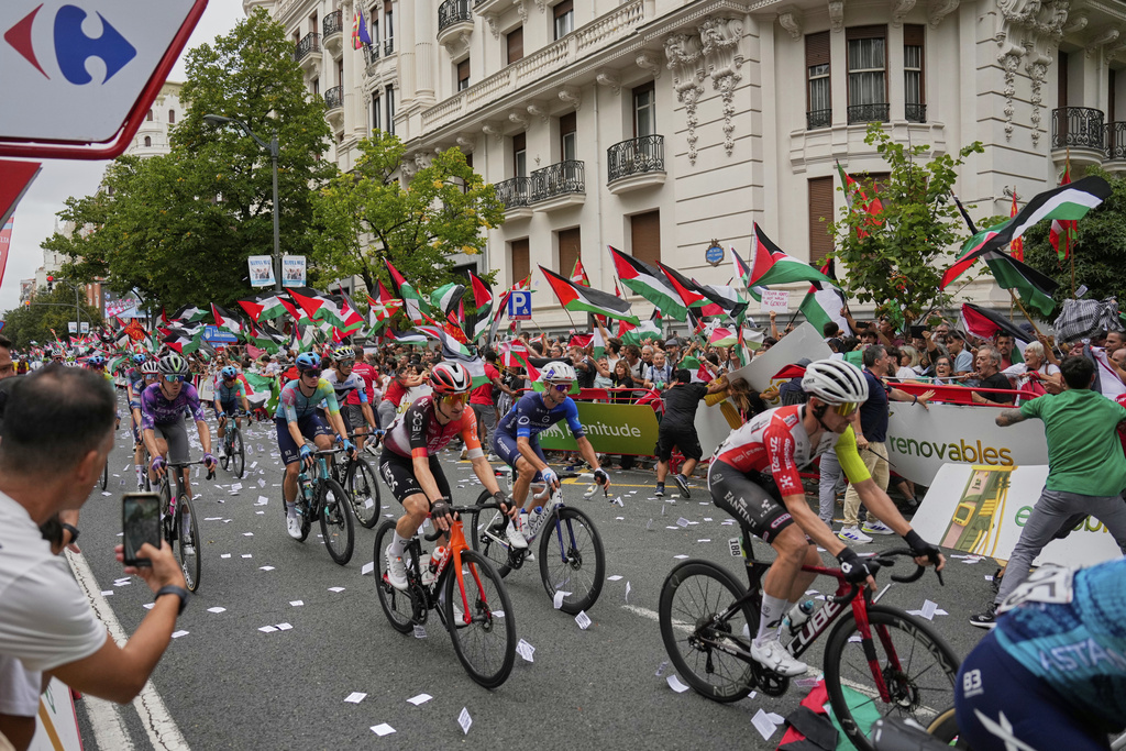People hold Palestinian flags as they try to disrupt the eleventh stage of the Spanish Vuelta cycling race, from Bilbao to Bilbao, Spain, Wednesday, Sept. 3, 2025. (AP Photo/Miguel Oses)