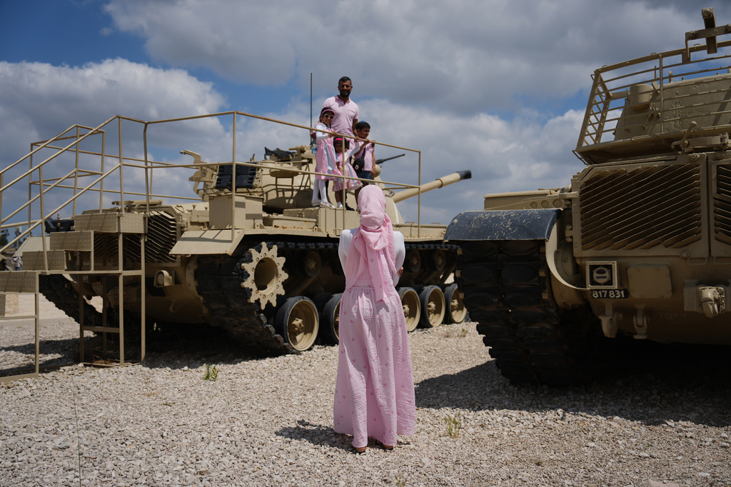 People take their photos on old tanks at the Armored Corps memorial site during a ceremony marking Israel's annual Memorial Day for the soldiers who died in the nation's conflicts and victims of nationalistic attacks, in Latrun, Israel, Tuesday, April 21, 2026. (AP Photo/Ariel Schalit)