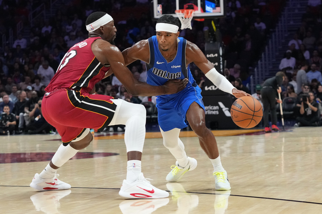 Miami Heat center Bam Adebayo (13) defends Dallas Mavericks guard Brandon Williams during the first half of an NBA basketball game Monday Nov. 24, 2025, in Miami. (AP Photo/Marta Lavandier)