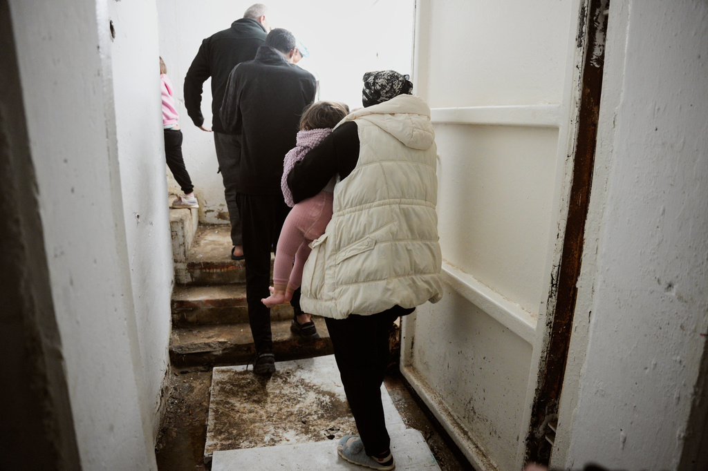 Residents take cover in a bomb shelter as air raid sirens warn of incoming Iranian missile strikes, in Beersheba, southern Israel Sunday, March 29, 2026. (AP Photo/Maya Levin)