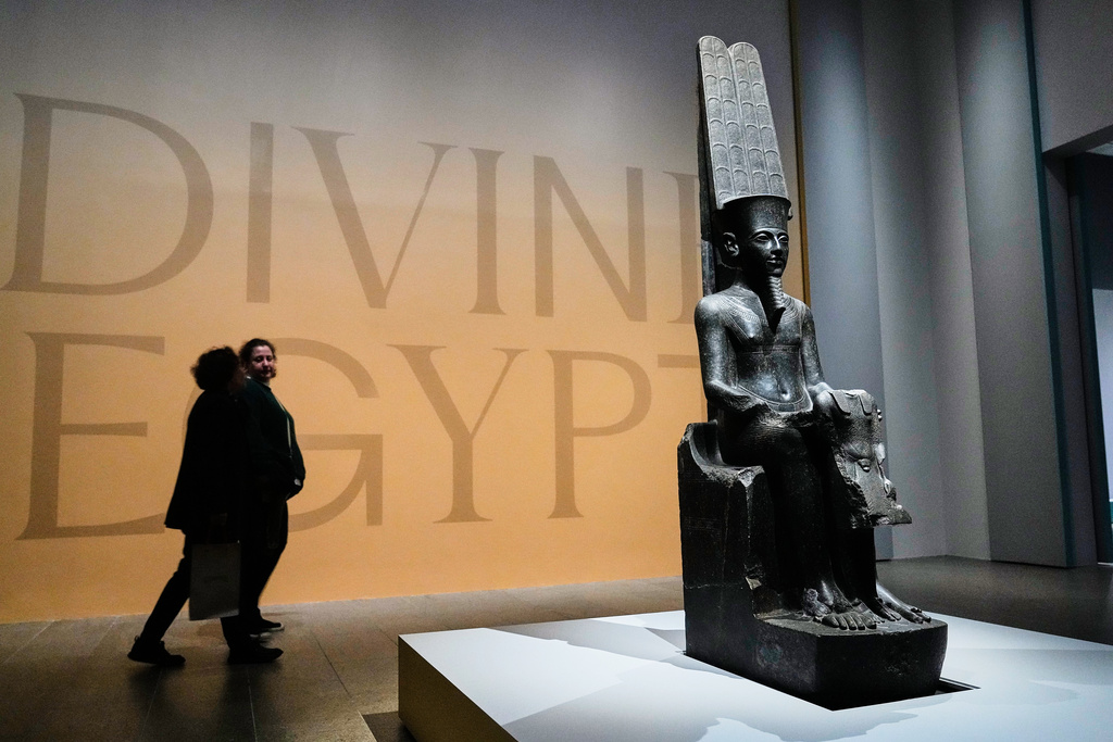 A statue of Amen-Re presenting and protecting King Tutankhamun is displayed in the Divine Egypt exhibition, at the Metropolitan Museum of Art, in New York, Tuesday, Oct. 14, 2025. (AP Photo/Richard Drew)