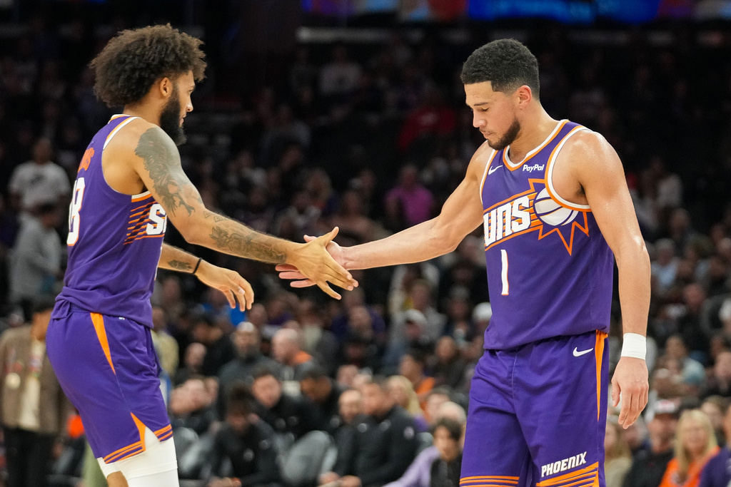Phoenix Suns forward Isaiah Livers (18) slaps hands with Devin Booker (1) during the second half of an NBA basketball game against San Antonio Spurs in Phoenix, Sunday, Nov. 23, 2025. (AP Photo/Darryl Webb)