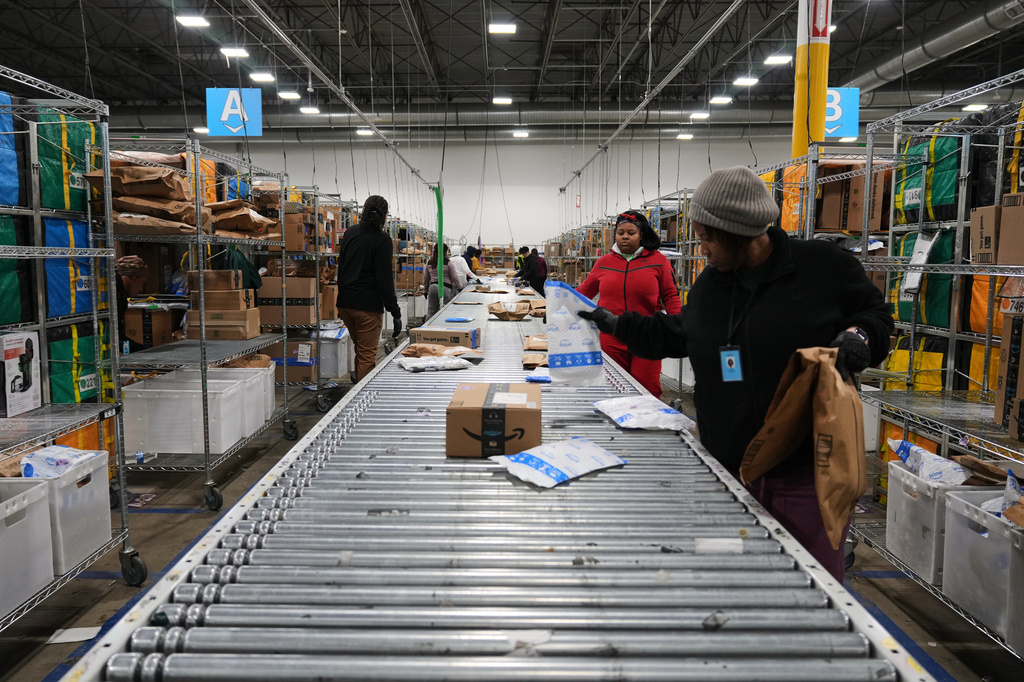 Amazon employees sort packages at a last-mile delivery center in Seaford, Del., Wednesday, Jan. 21, 2026. (AP Photo/Stephanie Scarbrough)