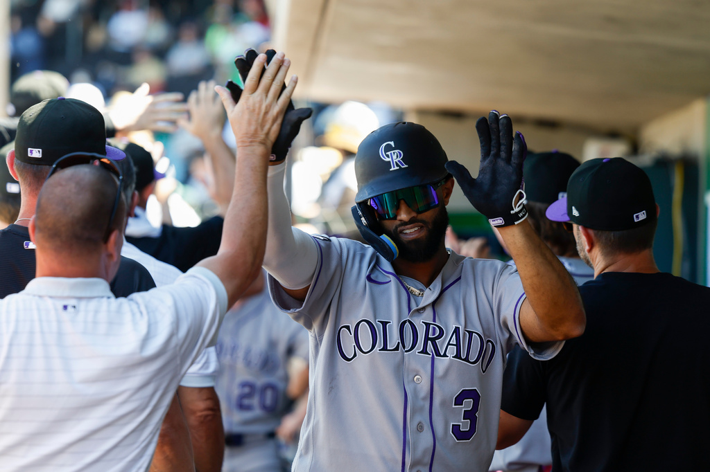 Colorado Rockies' Willi Castro (3) is greeted by teammates after hitting a grand slam during the eighth inning of a baseball game against the Athletics, Sunday, June 14, 2026, in Las Vegas. (AP Photo/Caroline Brehman)