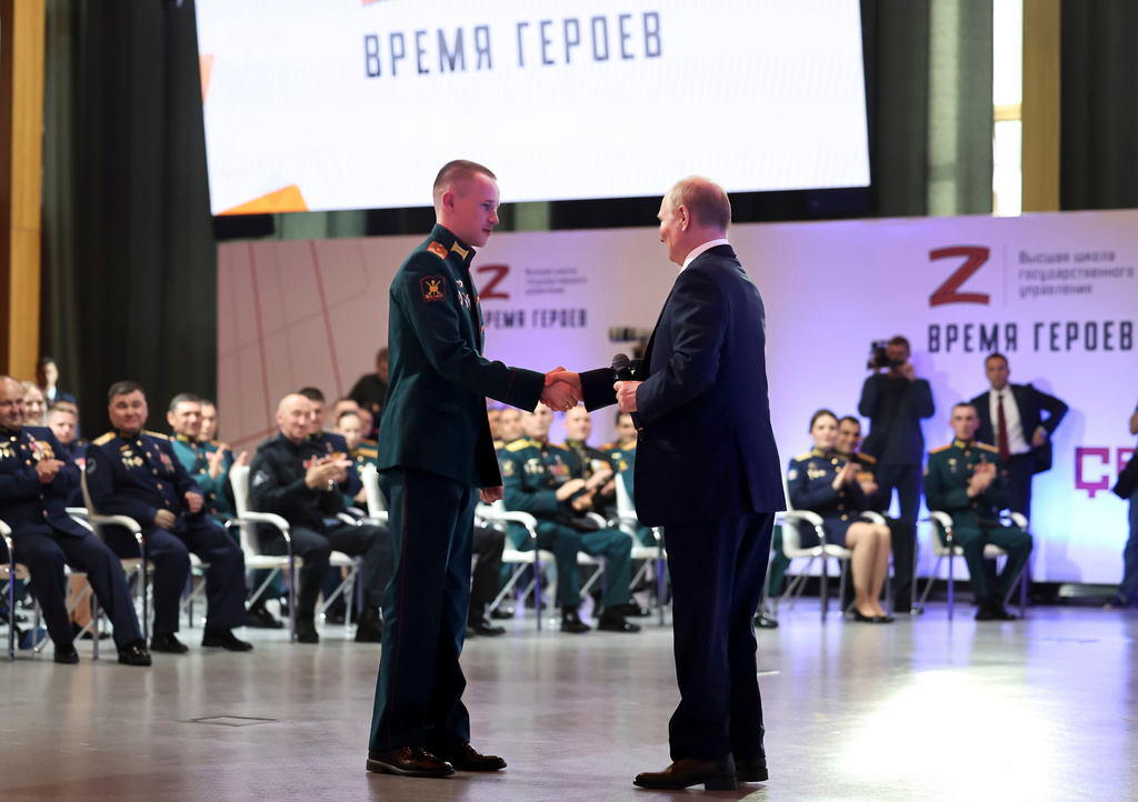 FILE - Russian President Vladimir Putin, right, congratulates Stepan Belov, who was named a Hero of Russia, during a meeting with participants of the "Time of Heroes" project designed to help veterans become government administrators, at a venue outside Solnechnogorsk, Russia, on Friday, June 14, 2024. (Alexander Kazakov, Sputnik, Kremlin Pool Photo via AP)