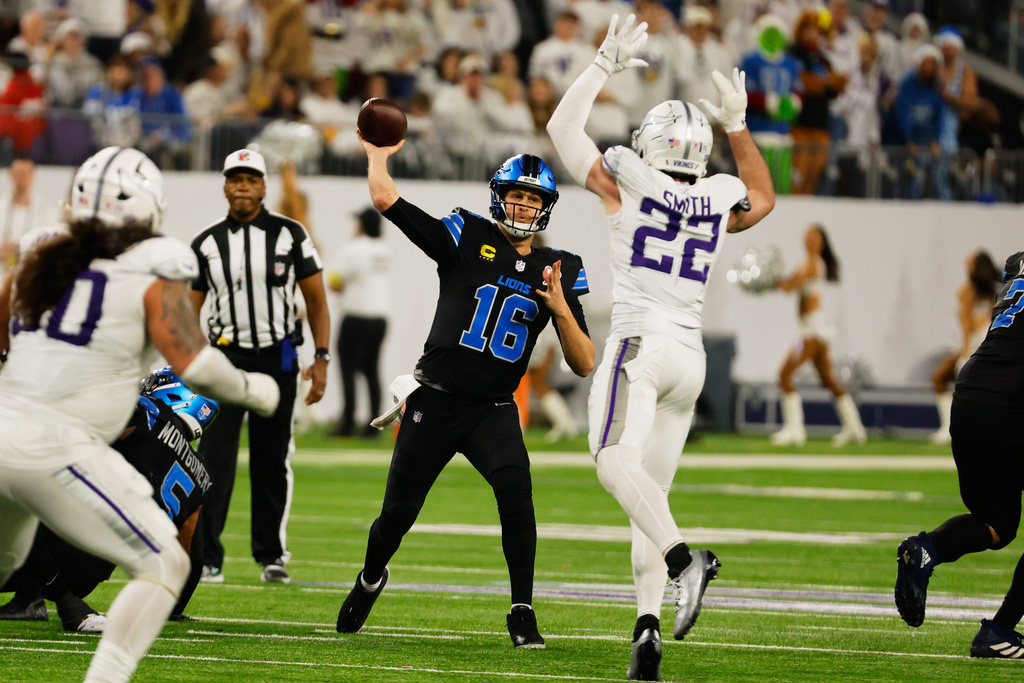 Detroit Lions quarterback Jared Goff (16) throws under pressure from Minnesota Vikings safety Harrison Smith (22) during the second half of an NFL football game, Thursday, Dec. 25, 2025, in Minneapolis. (AP Photo/Bruce Kluckhohn)
