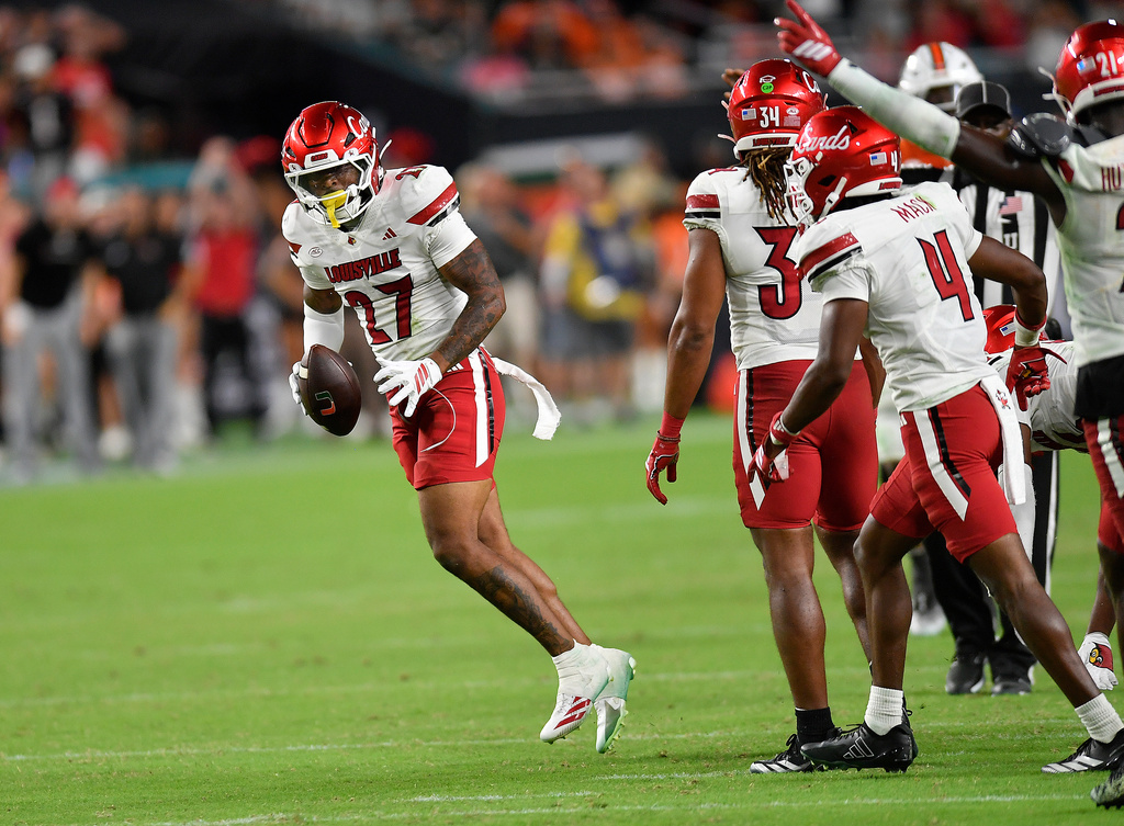 Louisville defensive back Jojo Evans Jr. (27) celebrates after intercepting the ball during the second half of an NCAA college football game against Miami, Friday, Oct. 17, 2025, in Miami Gardens, Fla. (AP Photo/Michael Laughlin)