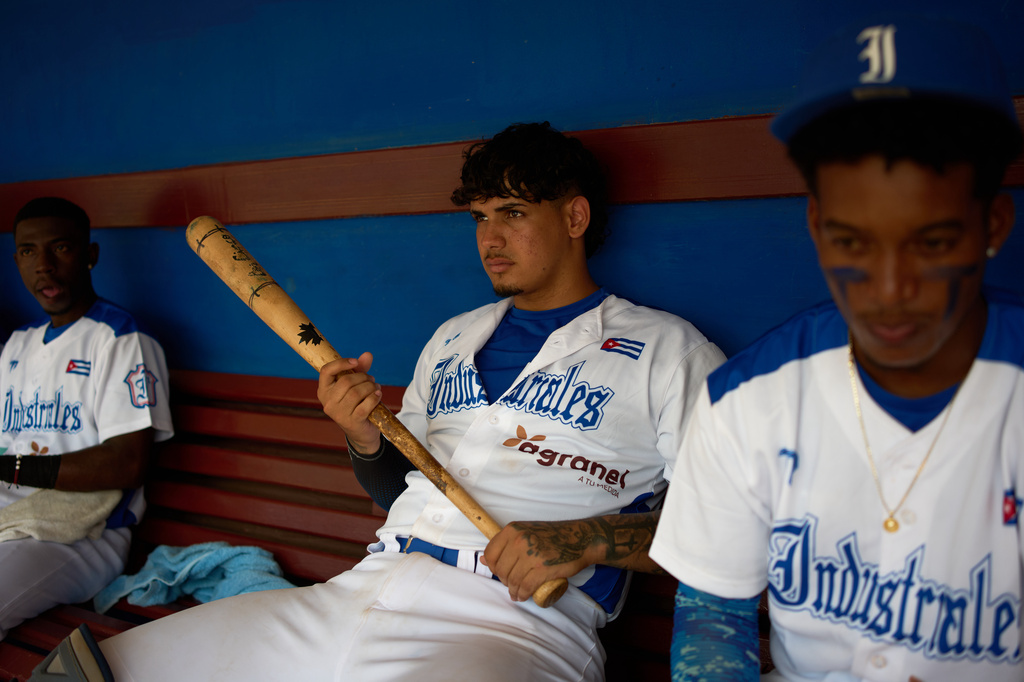 An Industriales player, wearing a jersey featuring a private sponsor logo, holds a baseball bat before a game against Pinar del R&iacute;o in Havana, Cuba, Wednesday, Oct. 7, 2026. (AP Photo/Ramon Espinosa)