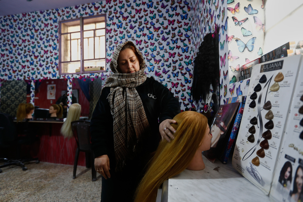 Hairstylist Aliaa al Jafar stands in her studio during an interview in the Kurdish-majority neighborhood of Sheikh Maqsoud, in Aleppo, Syria, Saturday, Feb. 14, 2026. (AP Photo/Omar Sanadiki)