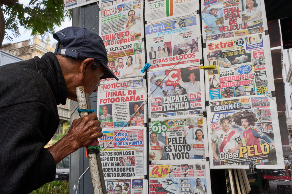 A man reads newspapers' front pages on the previous day's presidential election runoff in Lima, Peru, Monday, June 8, 2026. (AP Photo/Rodrigo Abd)