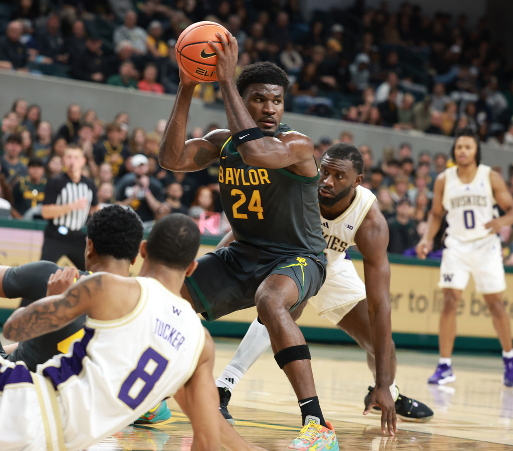 Baylor guard Tounde Yessoufou (24) pulls down a rebound over Washington center Franck Kepnang, right, in the first half of an NCAA college basketball game, Sunday, Nov. 9, 2025, in Waco, Texas. (Rod Aydelotte/Waco Tribune-Herald via AP)