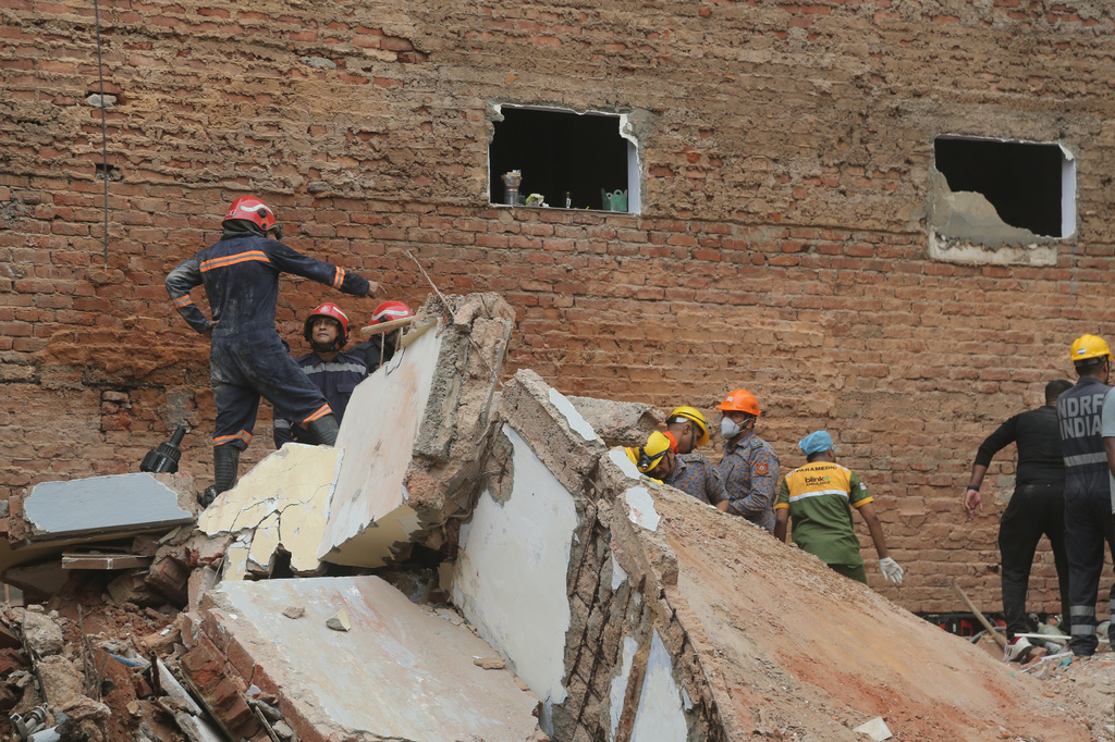 Rescue workers look for the trapped survivors under the debris of a building that collapsed in New Delhi, India, Sunday, Sept. 6, 2026.(AP Photo/ Shekhar Yadav)