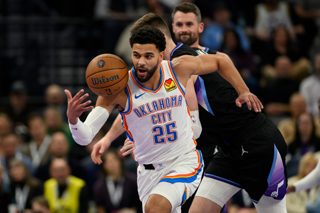 Oklahoma City Thunder guard Ajay Mitchell (25) steals the ball from Utah Jazz forward Kyle Filipowski, center, and leads a breakaway upcourt during the first half of an NBA Cup basketball game, Friday, Nov. 21, 2025, in Salt Lake City. (AP Photo/Tyler Tate)