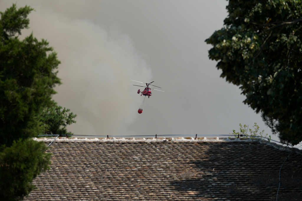 A firefighters helicopter battles a fire in Deliblatska Pescara (Deliblato Sands), near the village of Sumarak, 70 kilometers north-west of Belgrade, Serbia, Friday, Aug. 7, 2026. (AP Photo/Darko Vojinovic)