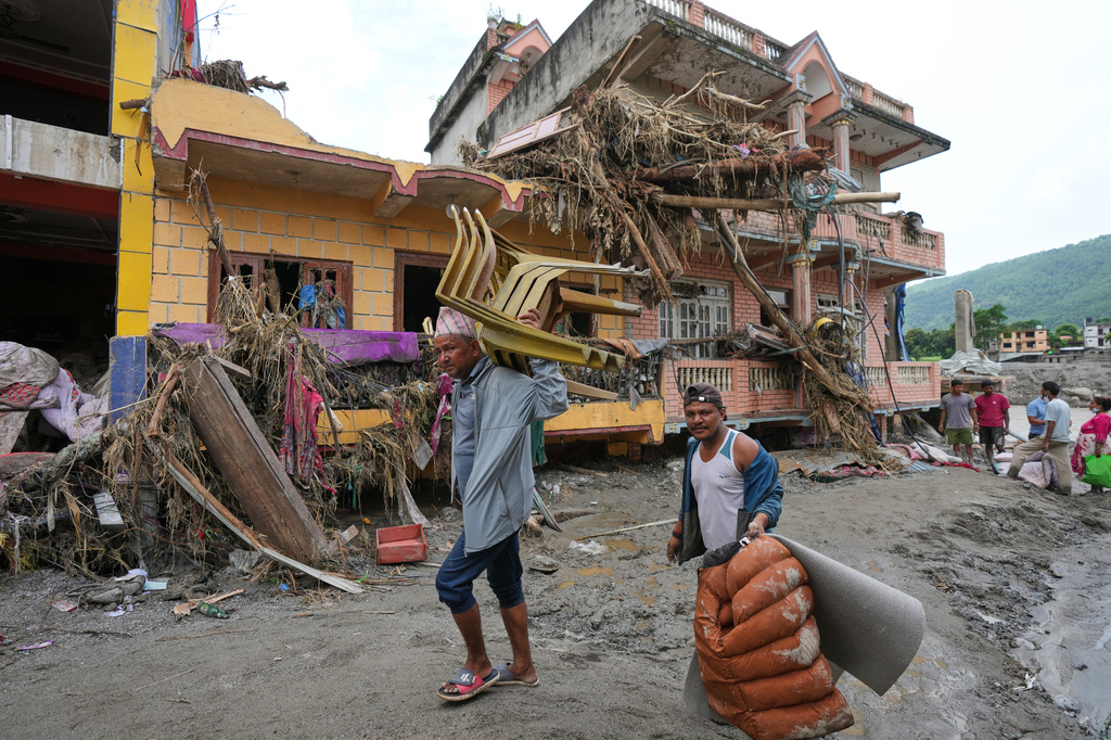 FILE - Residents leave with belongings salvaged from their flood-damaged homes in Devighat, in Nepal's Nuwakot district, Aug. 29, 2026. (AP Photo/Rajesh Kumar Singh, File)