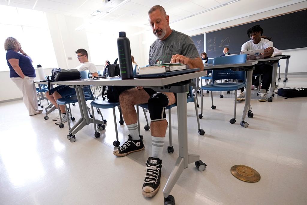 Lycoming College freshman Tom Cillo, center, organizes himself at the beginning of a first-year seminar, "The Politics of Coffee" on Monday Sept. 29, 2025 in Williamsport, Pa. (AP Photo/Gene J. Puskar)