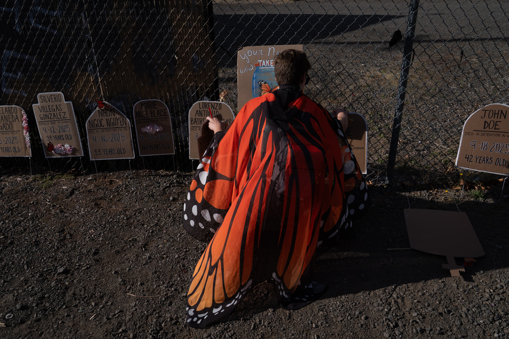 A protester puts out plaques for a memorial outside a U.S. Immigration and Customs Enforcement facility on Sunday, Sept. 28, 2025, in Portland, Ore. (AP Photo/Jenny Kane)