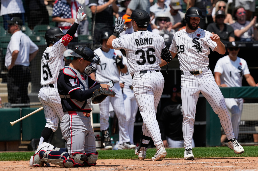Chicago White Sox's Drew Romo (36) celebrates with Rikuu Nishida (51), of Japan, and Tristan Peters (29) after hitting a two-run home run as Minnesota Twins catcher Alex Jackson reads a memo during the second inning of a baseball game in Chicago, Monday, May 25, 2026. (AP Photo/Nam Y. Huh)