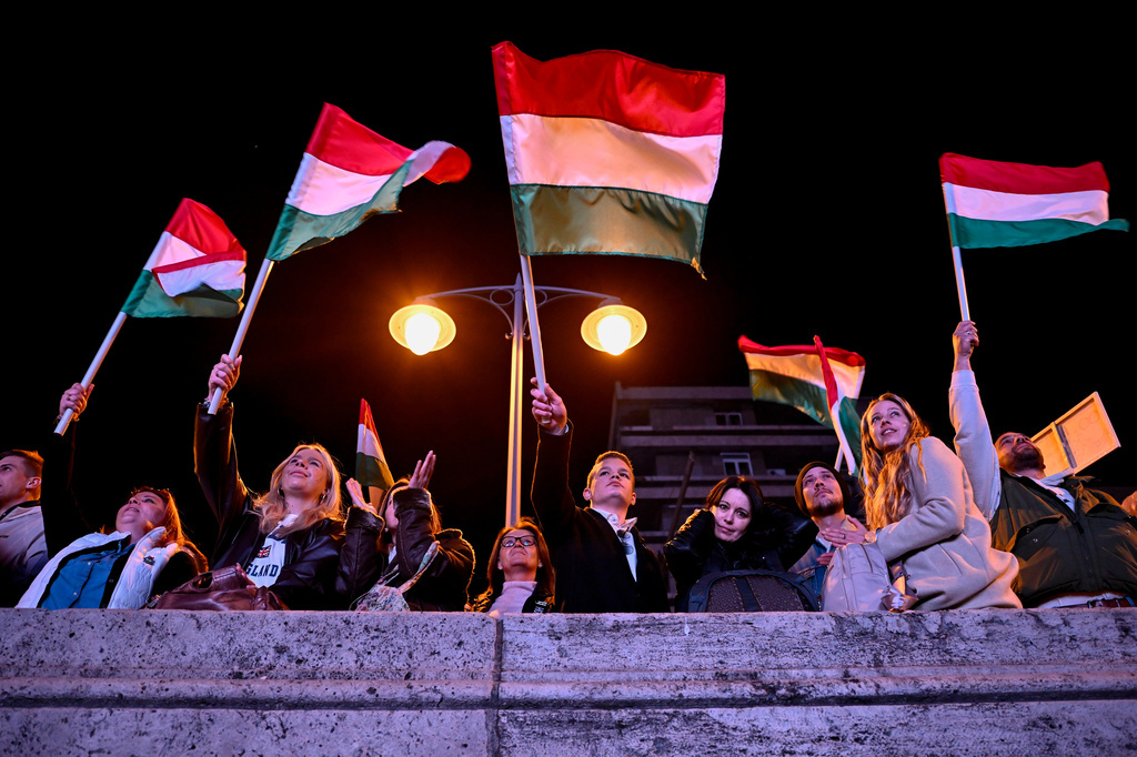 People react in the streets after the announcement of partial results of the Hungarian parliamentary election in Budapest, Hungary, Sunday, April 12, 2026. (AP Photo/Denes Erdos)
