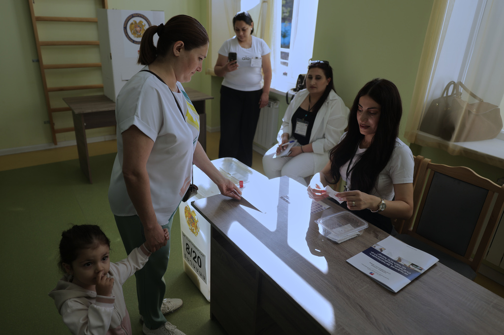 A woman gets a ballot at a polling station during the parliamentary election in Yerevan, Armenia, Sunday, June 7, 2026. (AP Photo/Anthony Pizzoferrato)
